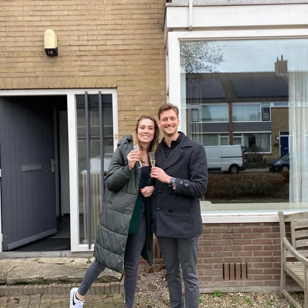 Sabine en Finn met champagne voor hun eerste huis.
